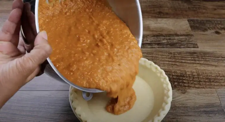 Filling the pie shell for sweet potato pie