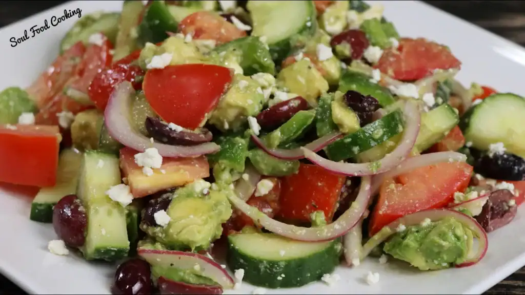 Greek Salad with tomatoes, red onion and feta cheese on a white plate