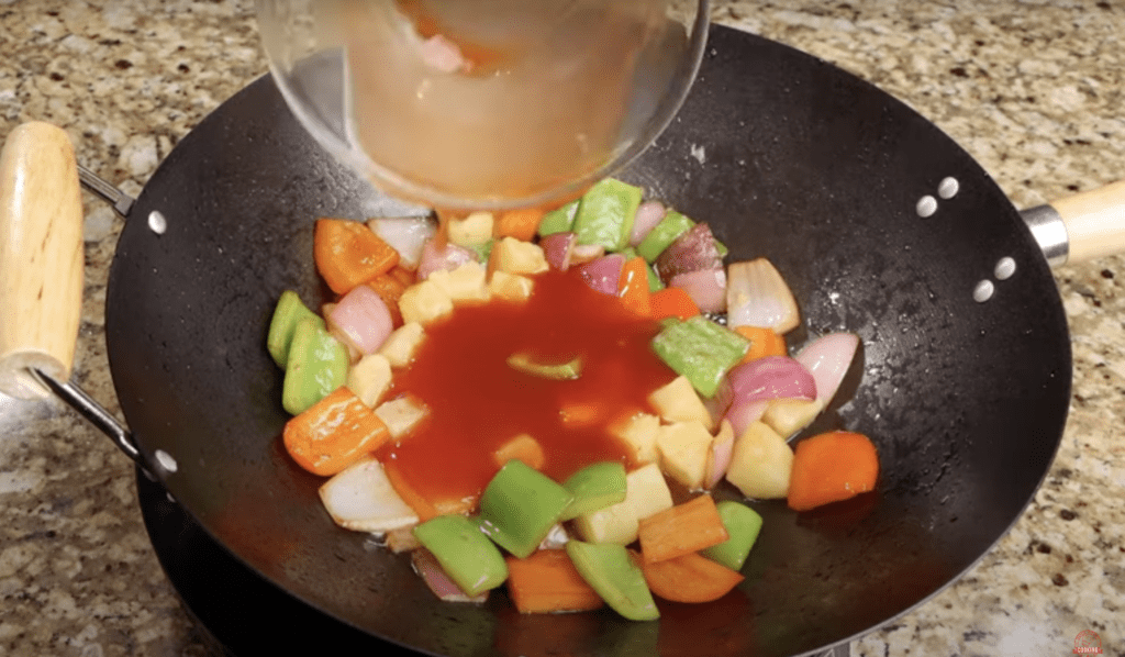 adding sauce to wok