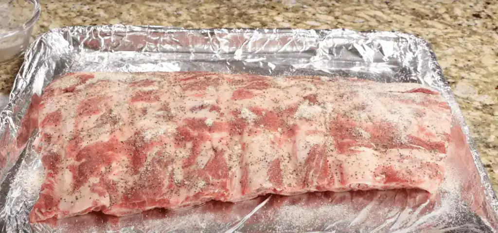 A rack of uncooked seasoned the ribs