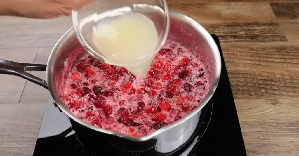 Adding the lemon juice to the cranberry sauce