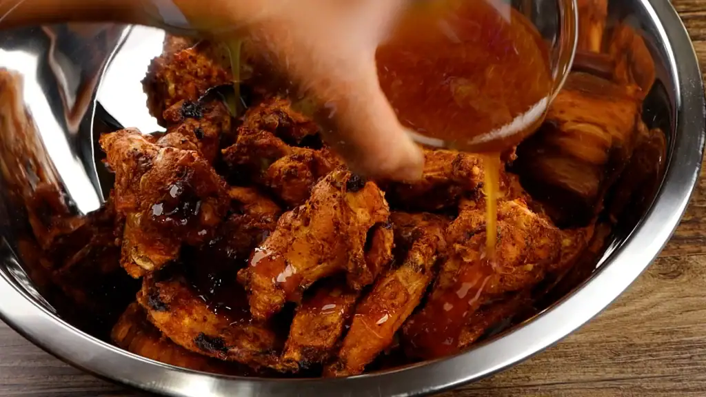 coating the wings with the honey cajun sauce