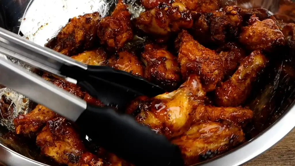 coating the wings with the honey cajun sauce