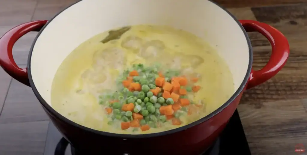 adding peas and carrots to chicken and dumplings