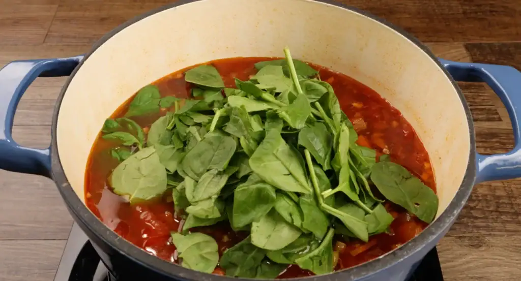 Adding the spinach to the Italian Sausage Soup