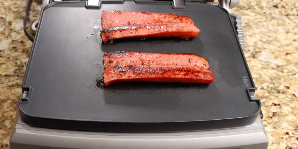 cooking the sausage on a griddle for breakfast sandwich