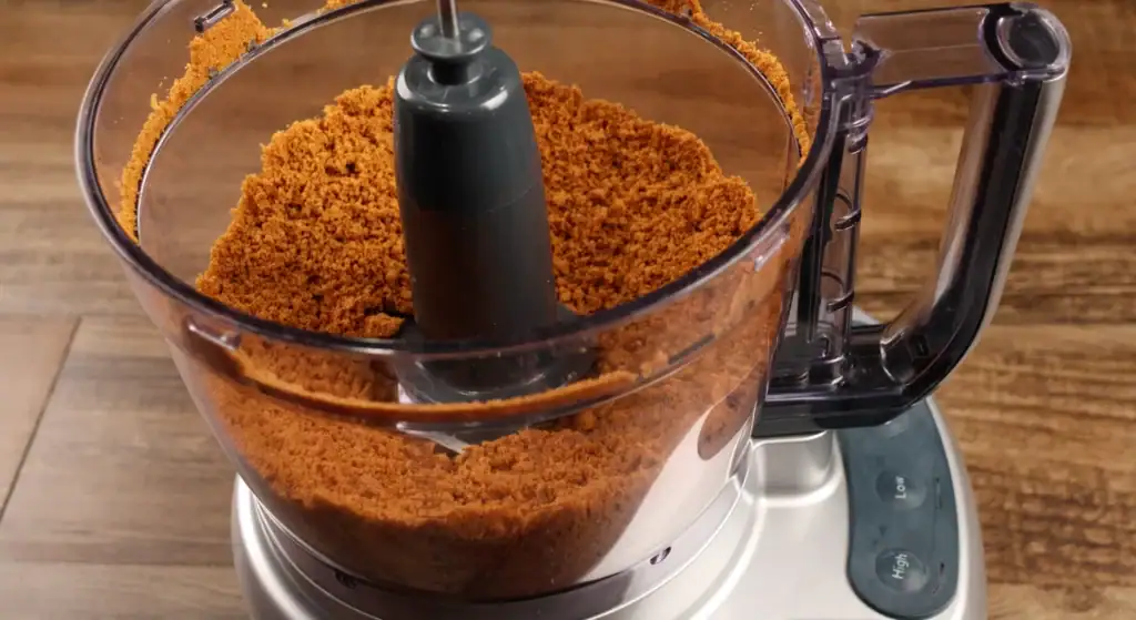 Biscoff cookies being blended in a food processor