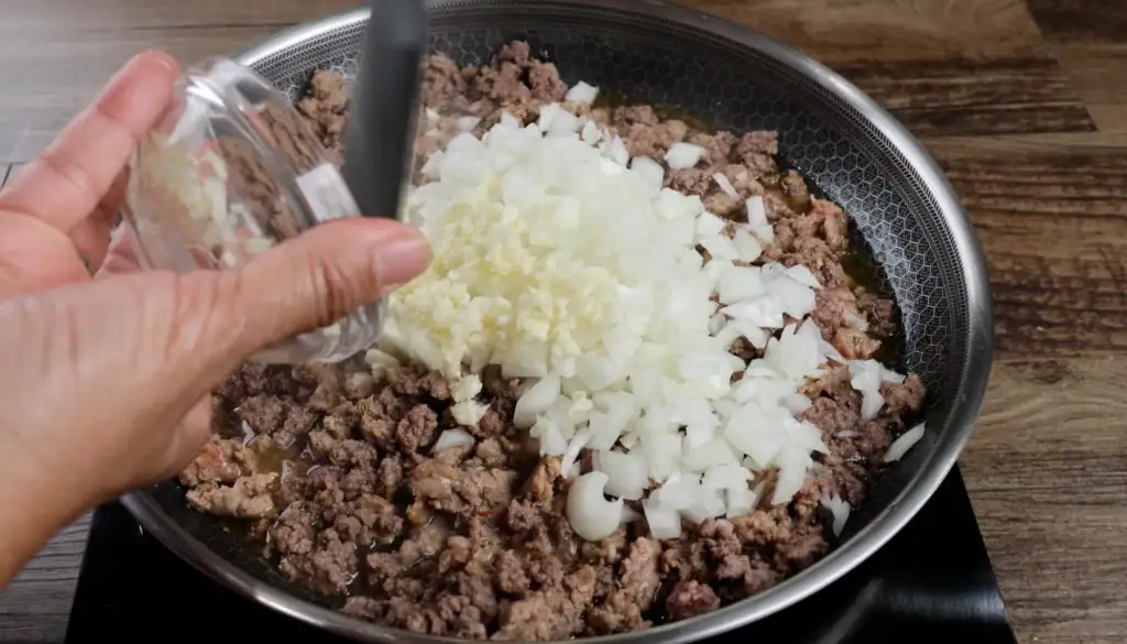 Adding the Onion and Garlic to the Ground Beef and Sausage