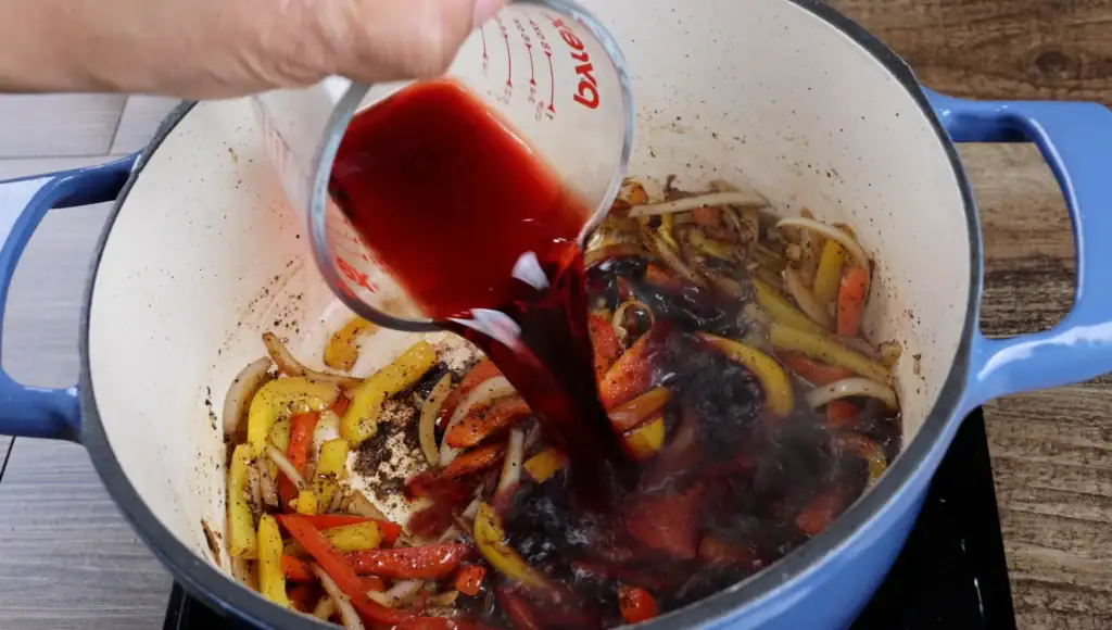 Adding the red wine for braised oxtails