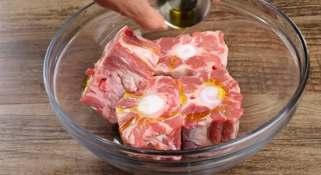 Pouring Olive Oil over Oxtails
