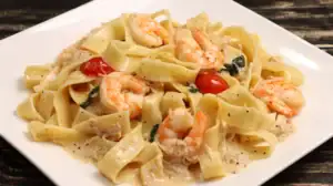 Seafood Pasta with cherry tomatoes and spinach on a white plate