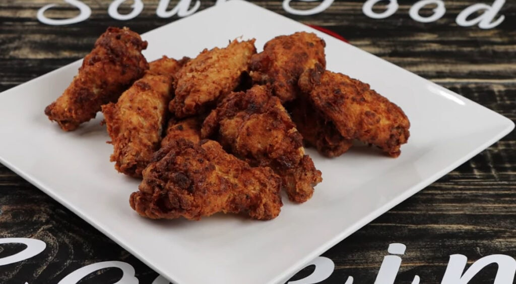 Crispy fried Ghost Pepper Wings piled on a white square plate ready to serve