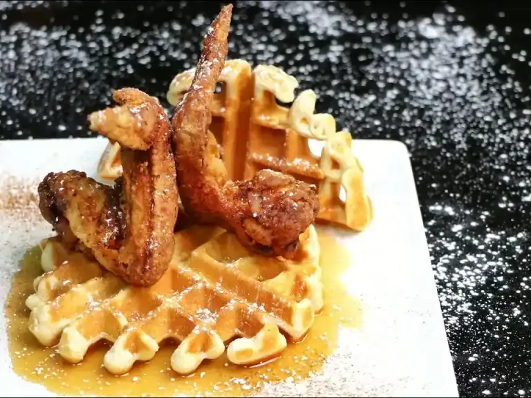 Chicken wings and waffles on a white plate
