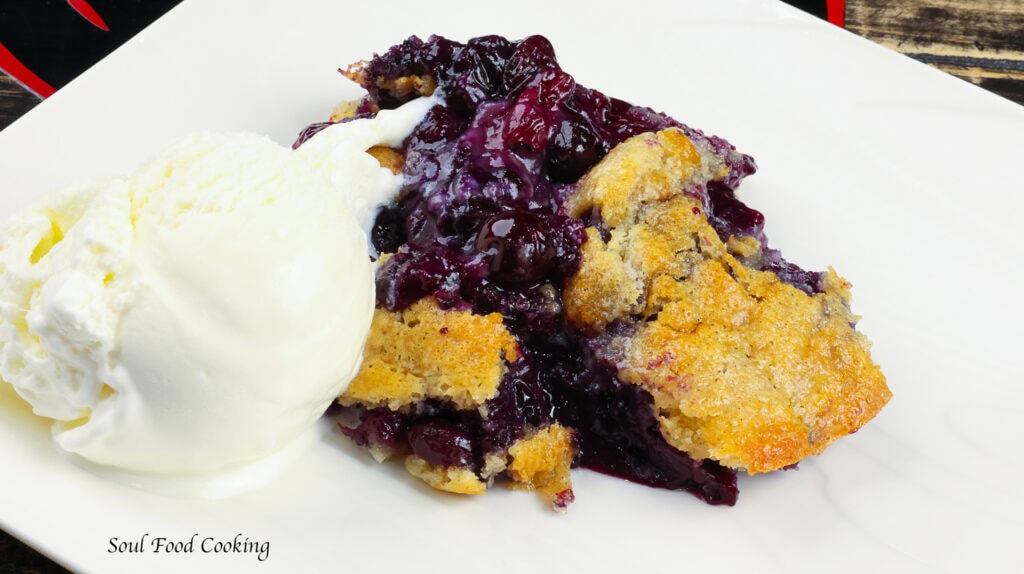 Blueberry Cobbler on a white plate with vanilla ice cream
