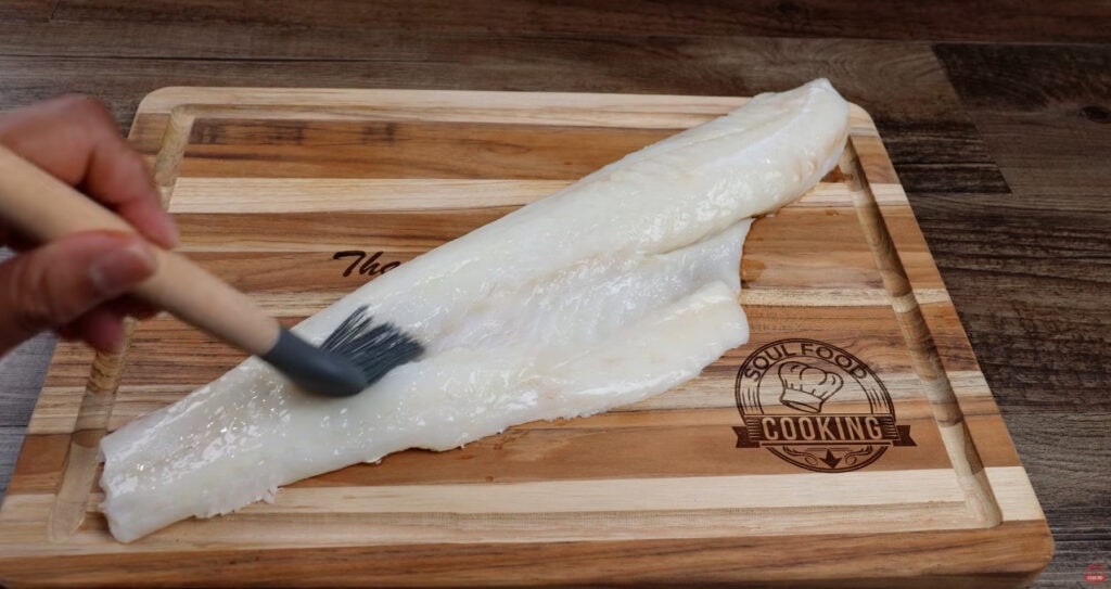 Brushing cod with melted butter