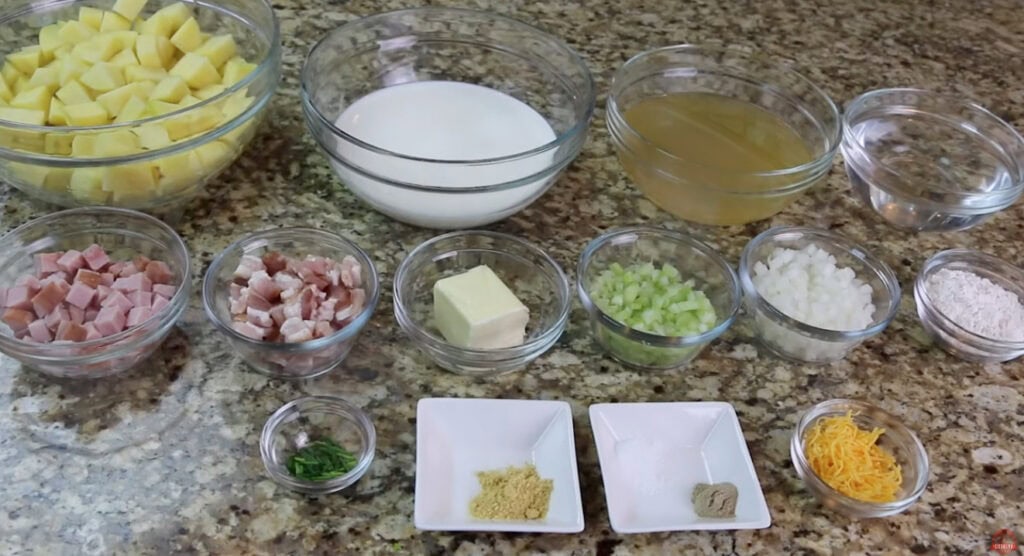 Ingredients for ham and potato soup arranged in bowls, including potatoes, ham, bacon, celery, onion, and half-and-half.