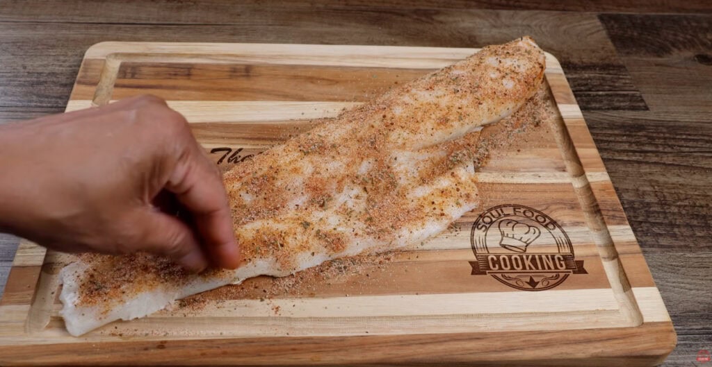 Seasoning the cod with the seasoning mixture.